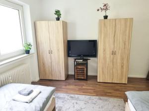 a room with two wooden cabinets and a tv at cozy Apartment with Balcony in Kronberg im Taunus