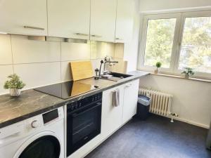 cocina blanca con fregadero y lavavajillas en Apartment with Balcony, en Kronberg im Taunus