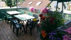 un patio con mesas, sillas y flores en Hotel Garni Schmid, en Neu-Ulm