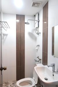 a bathroom with a toilet and a sink at COCOS HOTEL in Compostela