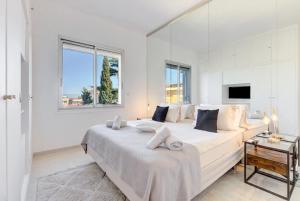 a white bedroom with a large bed and a window at Magnifique duplex, Croisette in Cannes