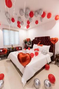 sypialnia z łóżkiem z czerwonymi i srebrnymi balonami w obiekcie Royal Hotel Sài Đồng - Long Biên w mieście Hanoi