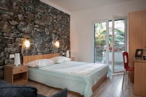 Un dormitorio con una cama y una pared de piedra. en Holiday Home Porat, en Podgora