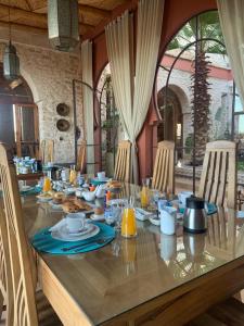 einen langen Tisch mit Teller mit Lebensmitteln drauf in der Unterkunft Villa des Hauts Mogador in Essaouira