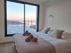 - une chambre avec 2 lits et une grande fenêtre dans l'établissement La Pointe sur l'eau - Vue mer - Piscine intérieure, à Plougastel-Daoulas 67 autres photos