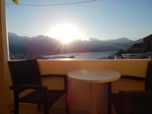 stół i krzesła na balkonie z widokiem na ocean w obiekcie Epiphany Apartments w mieście Karpatos