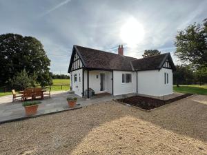 a white house with a patio and a table at Dell View - Charming & Cosy in Bentley