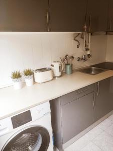 een keuken met een wasmachine en een wastafel bij O. Li Apart Estoril in Estoril