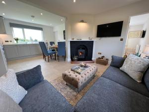 a living room with a couch and a fire place at Dell View - Charming & Cosy in Bentley