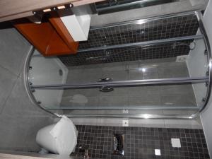 a glass shower in a bathroom with a sink at Epiphany Apartments in Karpathos Town