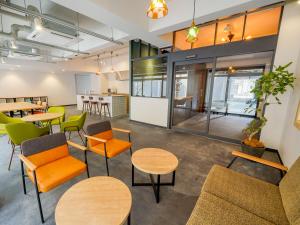 Una oficina con mesas y sillas y una cocina. en RESI STAY Heart, en Kioto