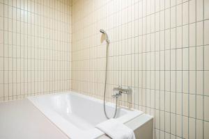 a bathroom with a bath tub with a shower at Hound Hotel Haeundae Signature in Busan