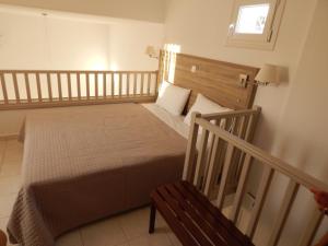 a small bedroom with a bed and a bench at Epiphany Apartments in Karpathos Town