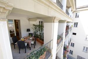 een patio met een tafel en stoelen op een balkon bij Ma Ville in Aosta