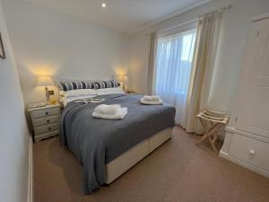 a bedroom with a bed with two towels on it at Dell View - Charming & Cosy in Bentley
