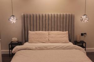 a bedroom with a bed with two night stands at Cozy apartment, two bedroom, full kitchen in Riyadh