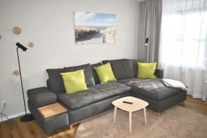 een woonkamer met een grijze bank en gele kussens bij Ostseeallee 4 Ferienwohnung Nr 21 Salz & Meer in Niendorf