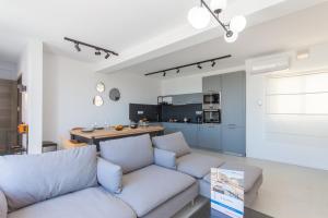 a living room with a couch and a kitchen at Seaview And Wellness Penthouse In Gozo - Happy Rentals in Xagħra