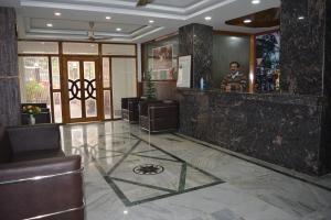 a man standing at a bar in a lobby at HOTEL SHIVA in Guwahati