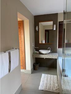 y baño con lavabo y espejo. en Elements Golf Reserve House 303, en Moheme