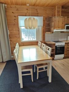 - une cuisine avec une table et des chaises en bois dans la chambre dans l'établissement Twin Peaks Urupää A Saariselkä, à Saariselka