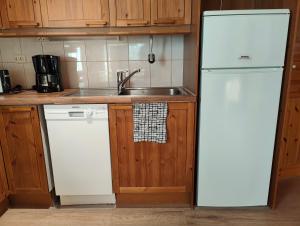 a kitchen with a white refrigerator and a sink at Twin Peaks Urupää A Saariselkä in Saariselka