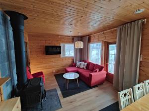 uma sala de estar com um sofá vermelho e uma mesa em Twin Peaks Urupää A Saariselkä em Saariselka