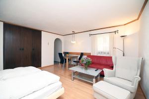 a bedroom with a bed and a couch and a table at 6303 Komplett renoviertes und stilvolles Studio zum Wohlfuehlen in Vulpera