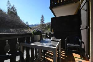 a table with two glasses of wine on a balcony at 6303 Komplett renoviertes und stilvolles Studio zum Wohlfuehlen in Vulpera