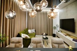 uma sala de estar com um sofá verde e lustres em Apartament ANIOŁY 29 em Zator
