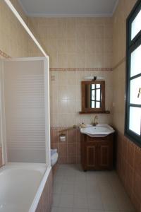 a bathroom with a tub shower and a sink at Polyxenia Hotel in Nafplio