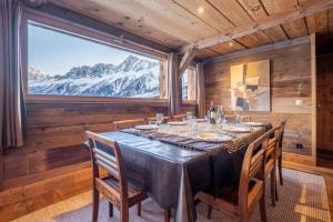 ein Esszimmer mit einem Tisch und einem großen Fenster in der Unterkunft Authenthic Chalet Ski on Les Houches Chamonix in Les Houches