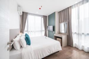 1 dormitorio con cama blanca y ventana en The Rich Residence Sukhumvit Nana en Bangkok