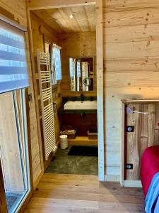 a bathroom with a tub and a sink in a log cabin at Chalet Horizon 180 4 étoiles Sauna in Gérardmer