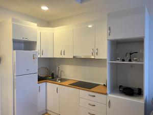 a kitchen with white cabinets and a white refrigerator at New Furnished Flat Central Location Free WIFI AC in Esenyurt
