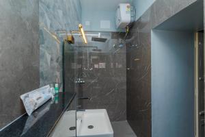 a bathroom with a toilet and a sink and a shower at HOTEL BLUEMOON in Tirunelveli