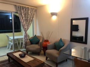 a living room with two chairs and a table at 3 BEDROOM-44 Kapenta Bay in Port Shepstone