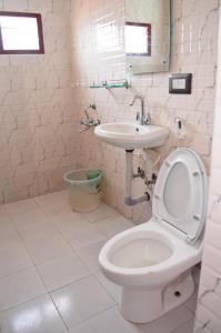 a bathroom with a toilet and a sink at Hill Heaven Home Stay in Kodaikānāl