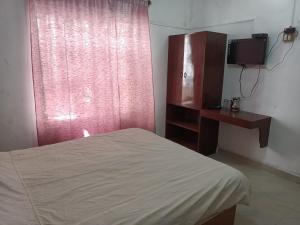 a bedroom with a bed and a red window at Hill Heaven Home Stay in Kodaikānāl