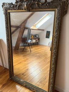 einen großen Spiegel in einem Zimmer mit Holzboden in der Unterkunft Wanatan Chambre d'hôtes in Penmarcʼh