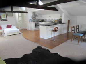 a room with a kitchen and a living room with a table at Royal Oak Apartment 1 in Cerne Abbas