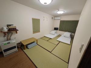 une pièce vide avec deux chaises et une table dans l'établissement Pension Megumiyuki, à Biei