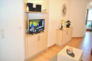 een woonkamer met een televisie in een kamer bij Residenz Ostseestrand Ferienwohnung Nr 09 in Scharbeutz