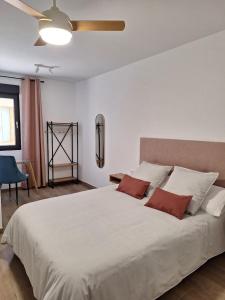 - une chambre avec un grand lit blanc et des oreillers rouges dans l'établissement Aromas del Jiloca, la Trufa Negra, à Calamocha