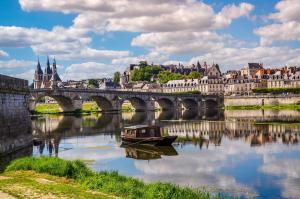 a boat on a river in front of a bridge at Cœur de Loire in Blois