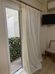 a window with a white curtain next to a window at Athens Central Apartment in Athens