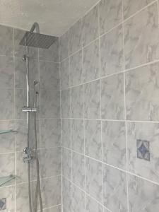 a bathroom with a shower with white tiles at Laret Guest House in London