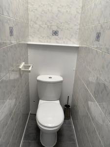 a bathroom with a white toilet in a stall at Laret Guest House in London