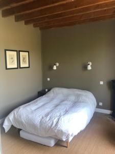 sypialnia z białym łóżkiem z dwoma światłami na ścianie w obiekcie Mon Plaisir de Carteret w mieście Barneville-Carteret