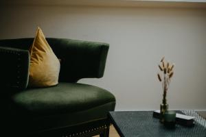 a green chair with a pillow and a table at Salzbergalm in Berchtesgaden